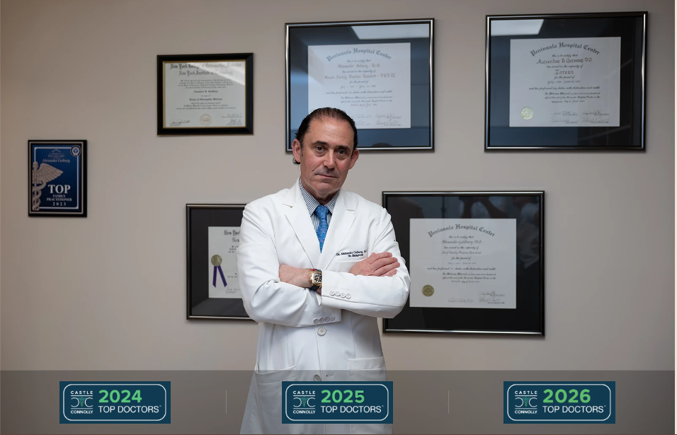 Dr. Alexander Golberg standing in front of his medical credentials and Top Doctors awards